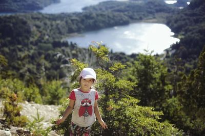 Portrait of cute girl standing against lake