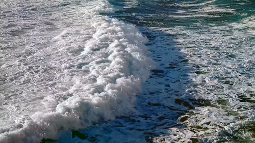 High angle view of waves rushing towards shore