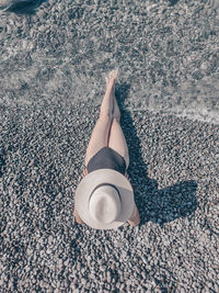 Low section of woman lying on sand