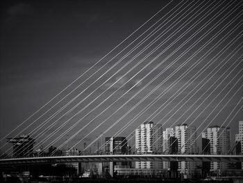 Low angle view of suspension bridge against sky