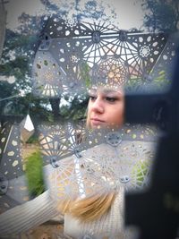 Portrait of young woman looking through glass