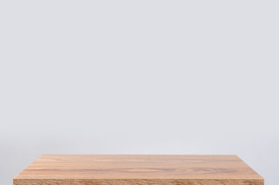 Close-up of wooden table against white background