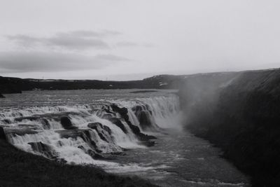 Scenic view of waterfall against sky