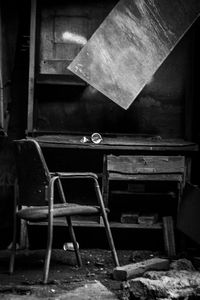 Empty chairs and table in abandoned building