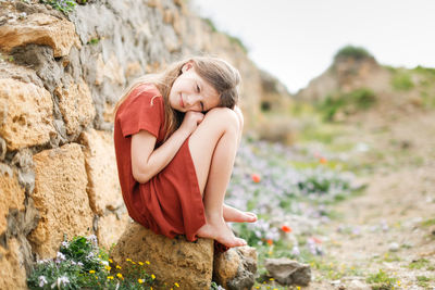 Young woman sitting on rock