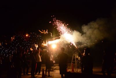 People watching firework display at night