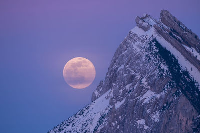 Low angle view of snowcapped mountains against sky at night