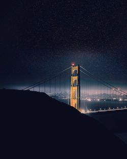Golden gate bridge over bay against clear sky at night