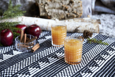 Apple spiced cider served on ice with apple and cinnamon