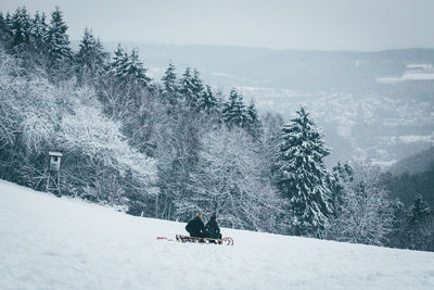 Person skiing on snow covered landscape against sky