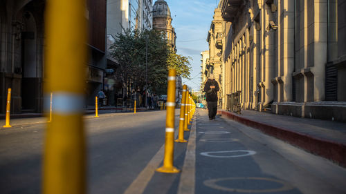 Rear view of people walking on street in city