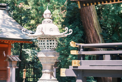 Low angle view of statue against trees and building