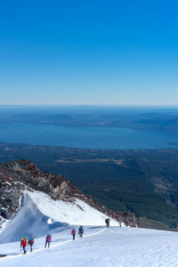 People on snow covered mountain against sky