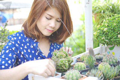 Beautiful woman looking at plant nursery at garden