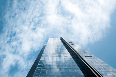 Low angle view of glass building against sky