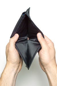 Close-up of hand holding black over white background