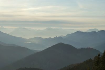 Scenic view of mountain range against cloudy sky during sunset