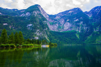 Scenic view of lake by mountains against sky