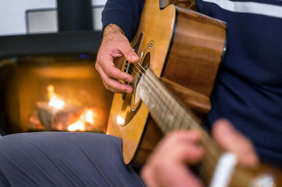 Midsection of man playing guitar