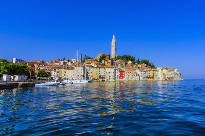 Panoramic view of sea and buildings against clear blue sky