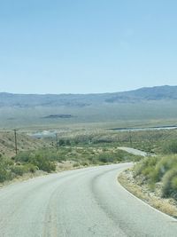 Empty road along countryside landscape