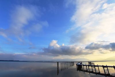 Pier on sea against sky during sunset