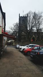 Cars on road in city against sky