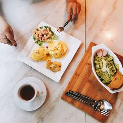 High angle view of woman eating brunch on table