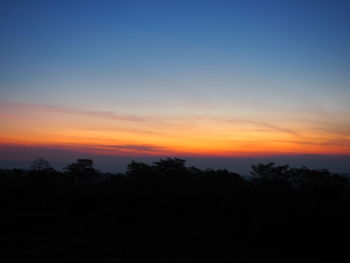 Silhouette trees against sky during sunset