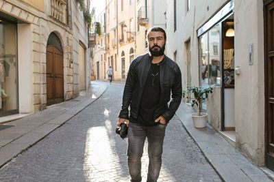 Portrait of young man standing in city