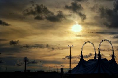 Low angle view of silhouette built structure against dramatic sky