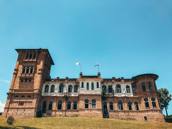 Low angle view of historical building against clear blue sky