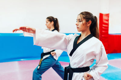 Young woman with instructor practicing martial arts