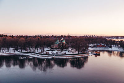 Scenic view of river by buildings against clear sky