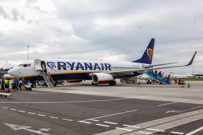 Airplane on airport runway against sky