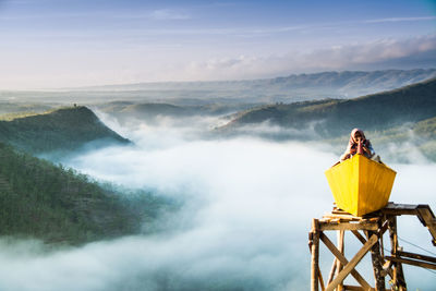 Man standing on mountain by sea against sky