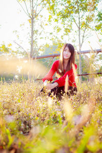 Full length of woman sitting on field