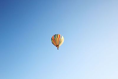 Low angle view of hot air balloon against clear blue sky
