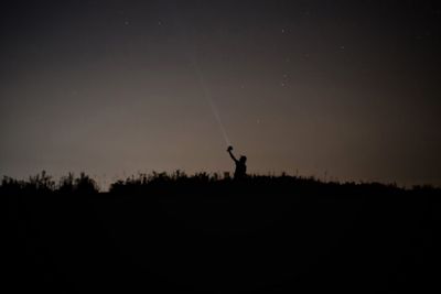Silhouette landscape against sky at night