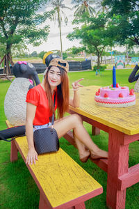 Young woman sitting on seat in park