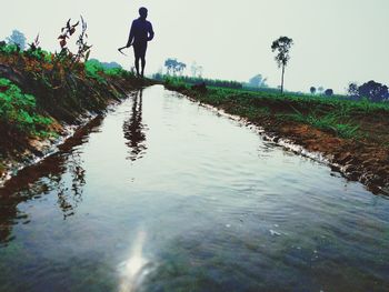 Rear view of man standing in water