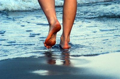 Low section of woman standing in water