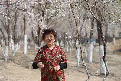 Senior woman standing at park during springtime