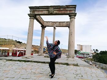 Woman posing while standing by los cuatro postes de avila against sky