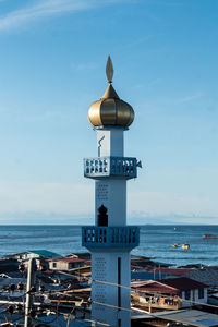 Information sign by sea against sky