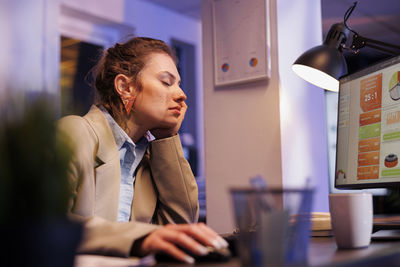 Side view of young businesswoman working at office