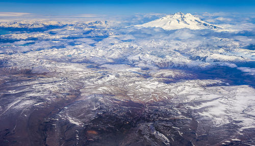 Aerial view of snowcapped mountains against sky