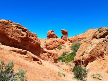 Rock formations in desert against clear blue sky