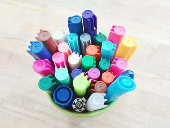 High angle view of colorful felt tip pens in desk organizer on wooden table