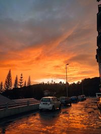 Cars on road against orange sky